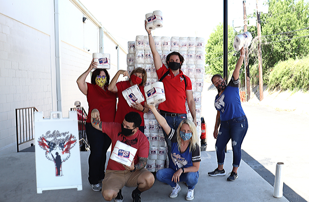 Soldiers' Angels staff raising toilet paper in the air for the winner of our T.P. contest