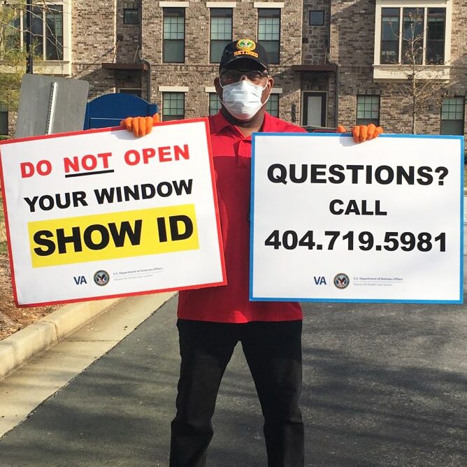 Volunteers in Atlanta hold signs ahead of a food distribution event.