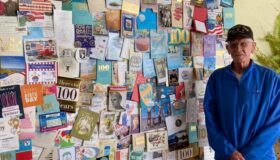 Veteran next to a wall of cards