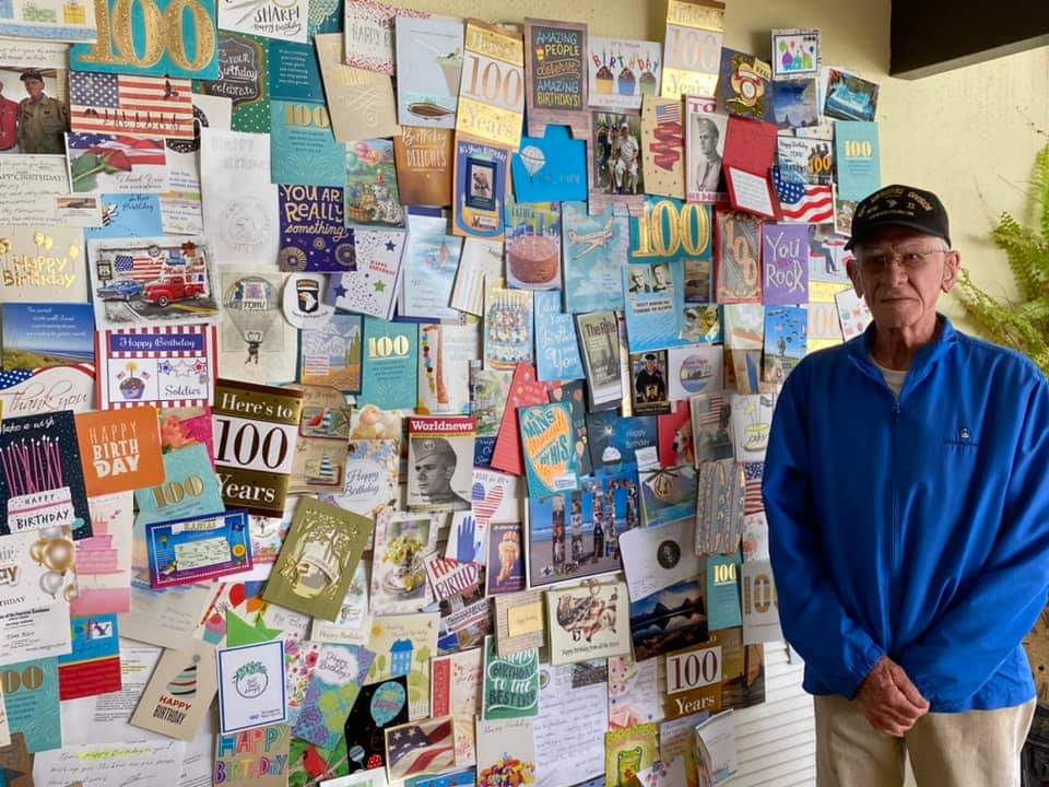 Veteran next to a wall of cards