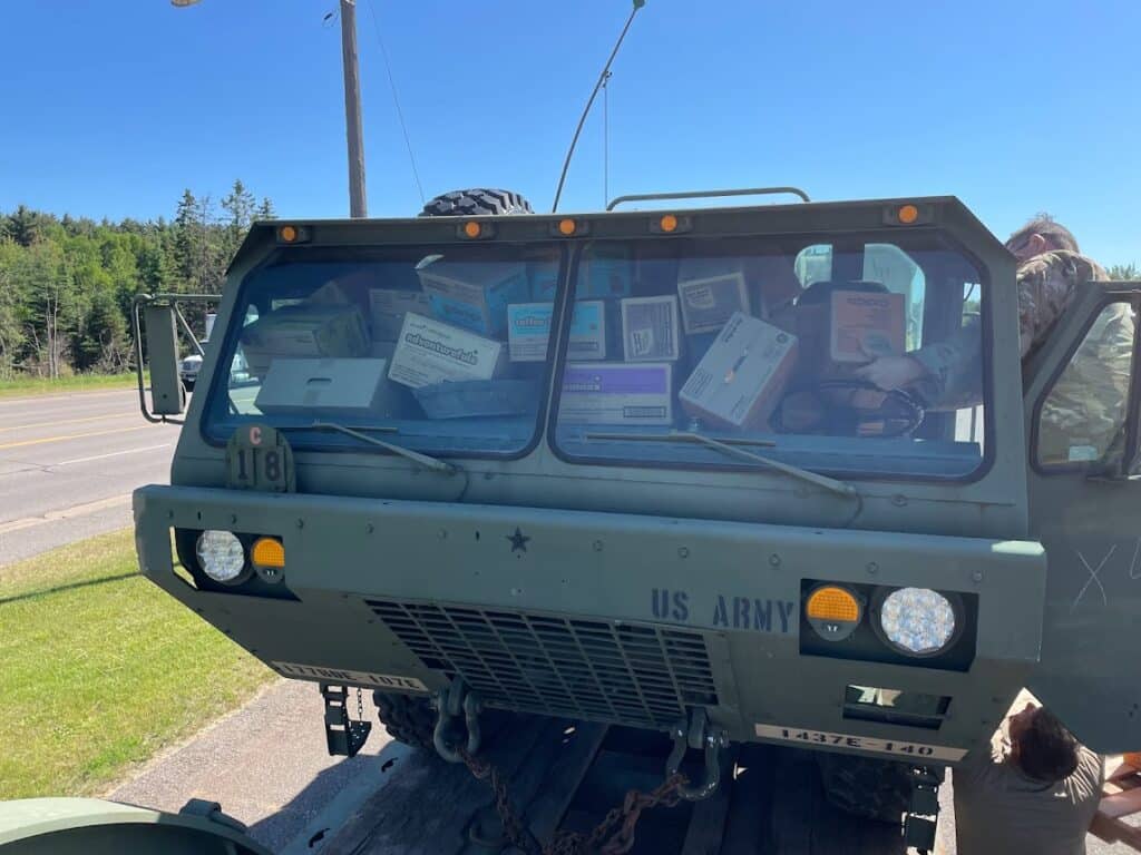 Girl Scout Cookies being loaded into a military vehicle 