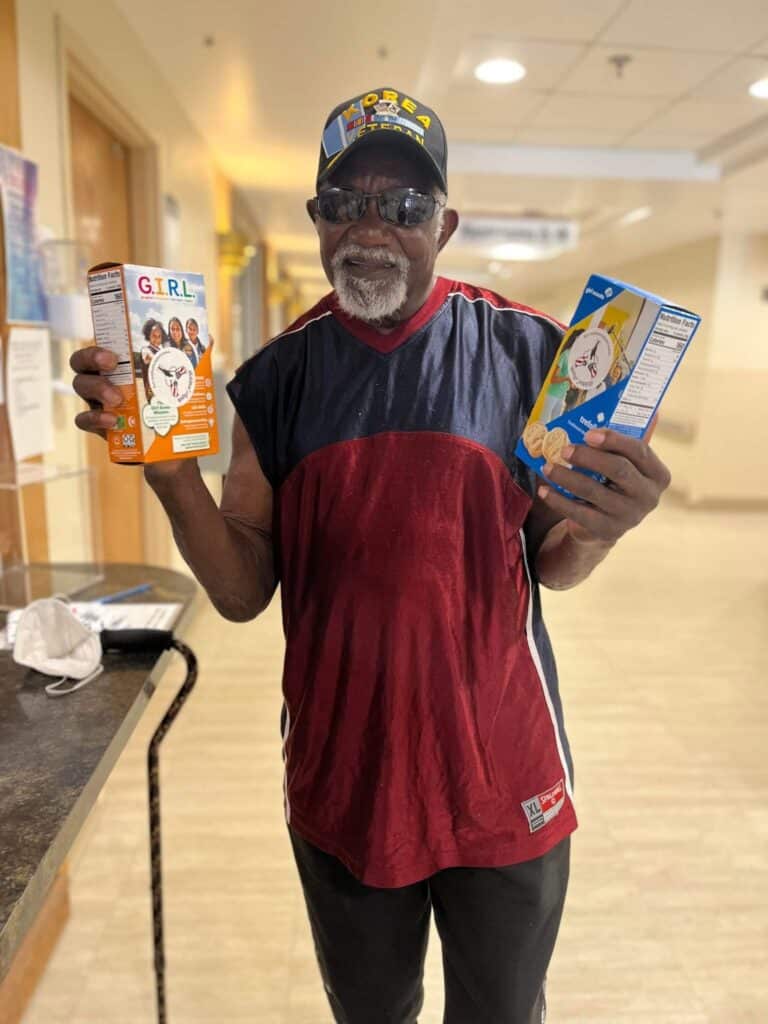 veteran holding boxes of Girl Scout cookies