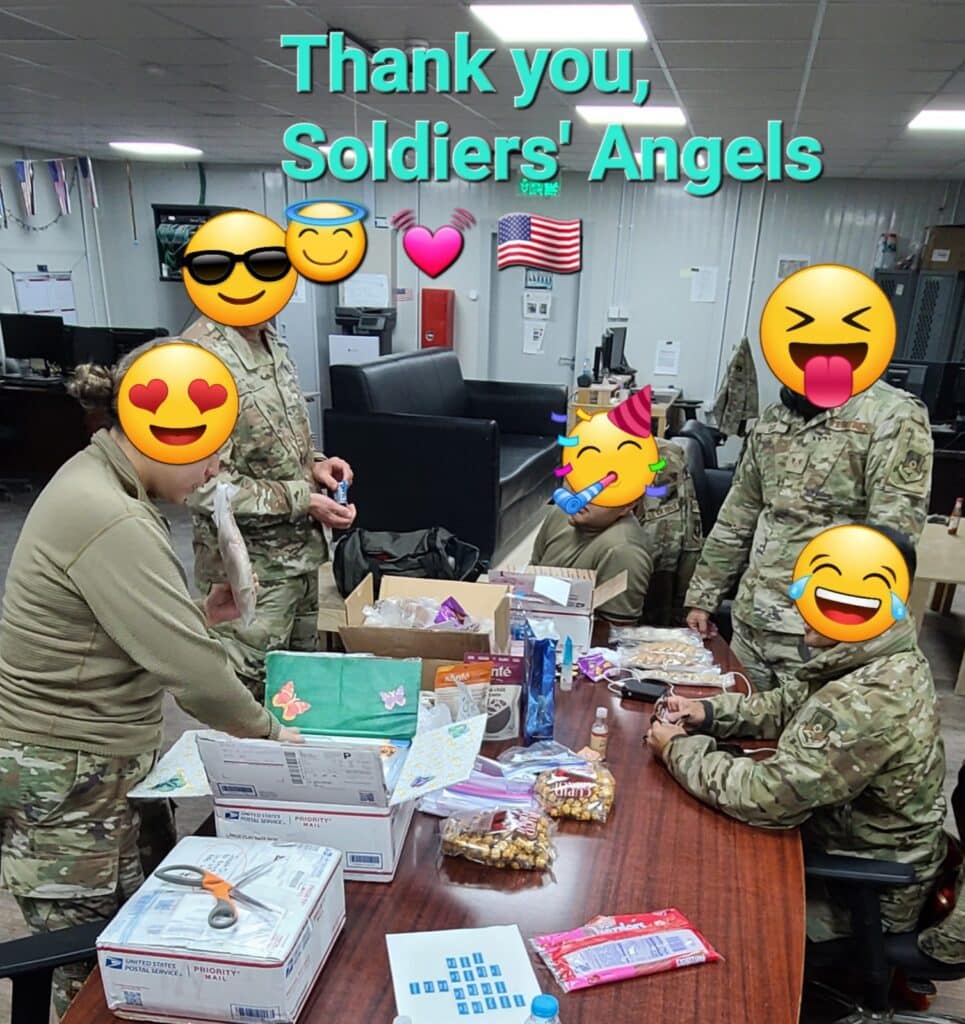 Happy Service Members at a table full of care packages