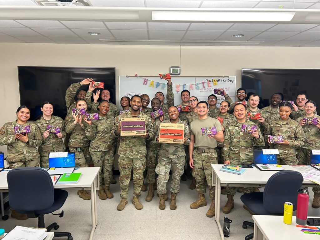 Deployed Service Members holding Girl Scout Cookies