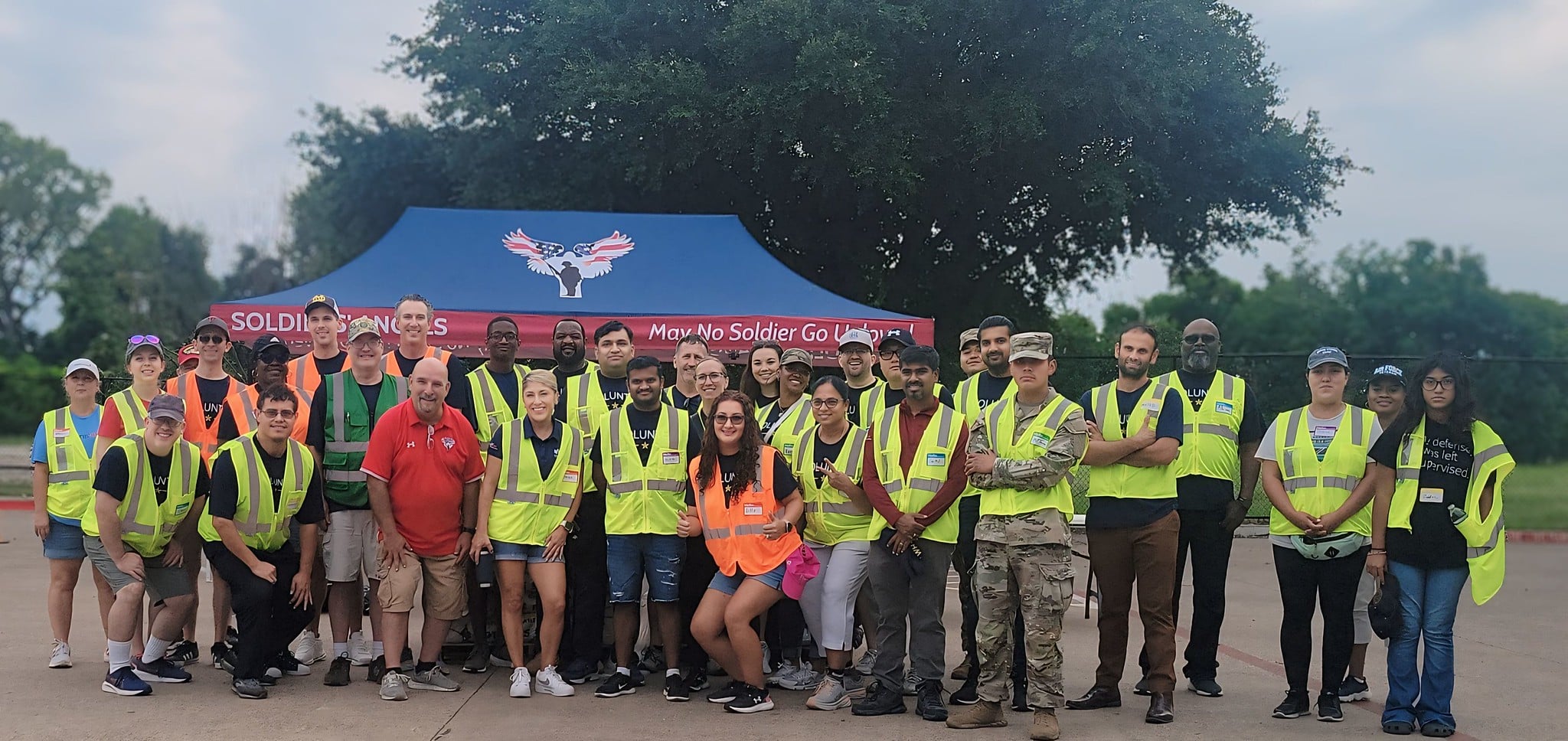 Volunteers distributing food to service members and veterans at an outdoor event