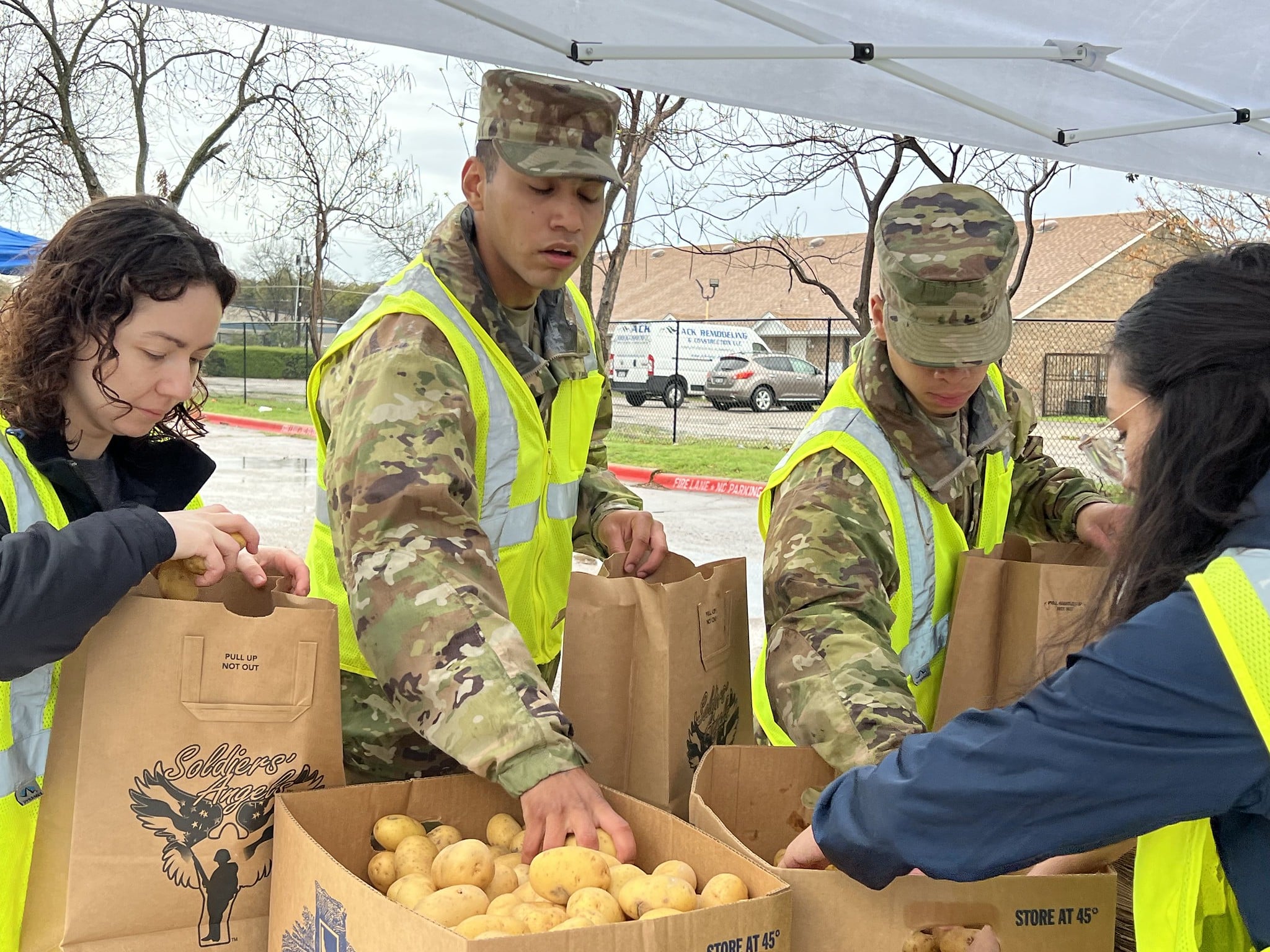 Soldiers' Angels volunteers in red shirts posing outdoors at a food distribution event in Atlanta, Georgia