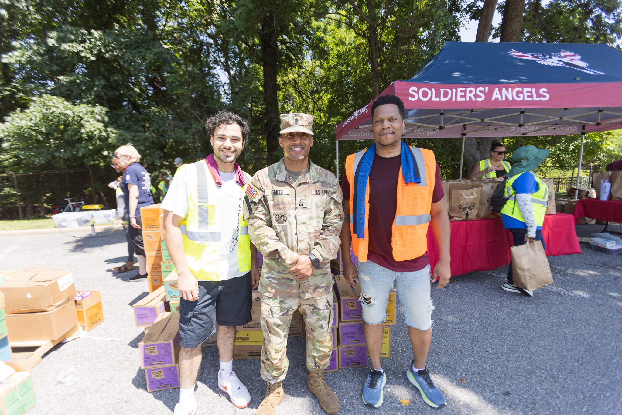 Soldiers' Angels volunteers in red shirts posing outdoors at a food distribution event in Atlanta, Georgia