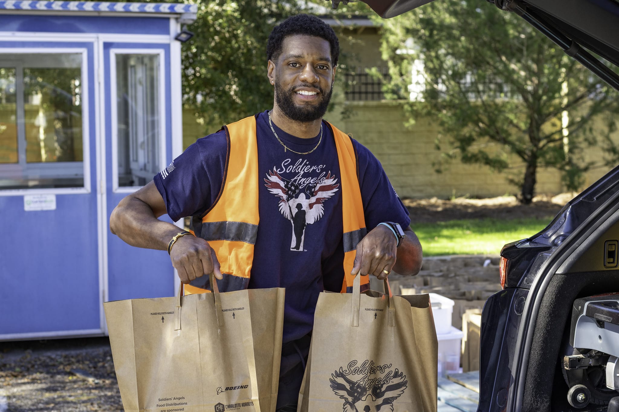 Volunteers distributing food to service members and veterans at an outdoor event